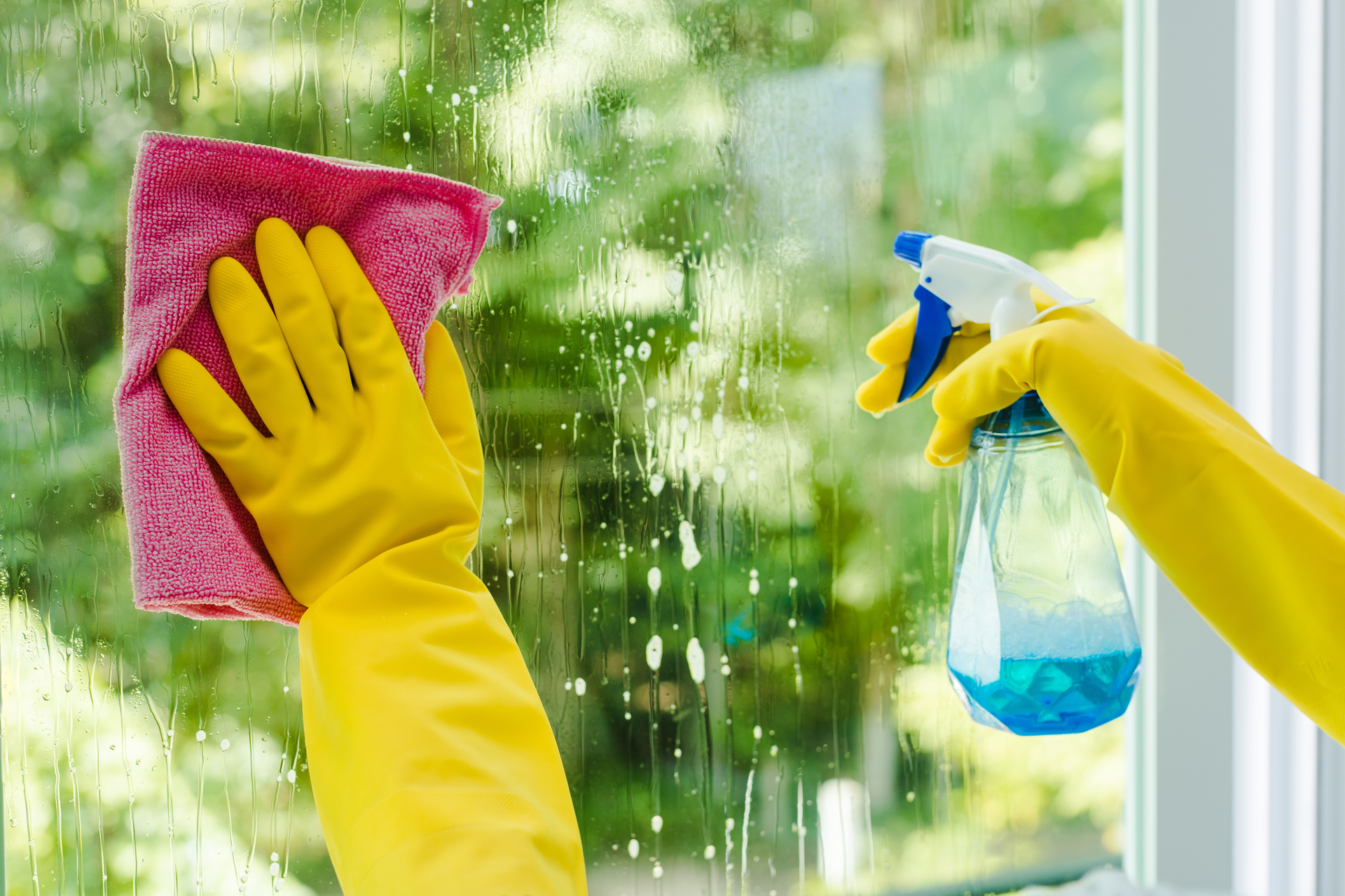 woman spraying and wiping glass
